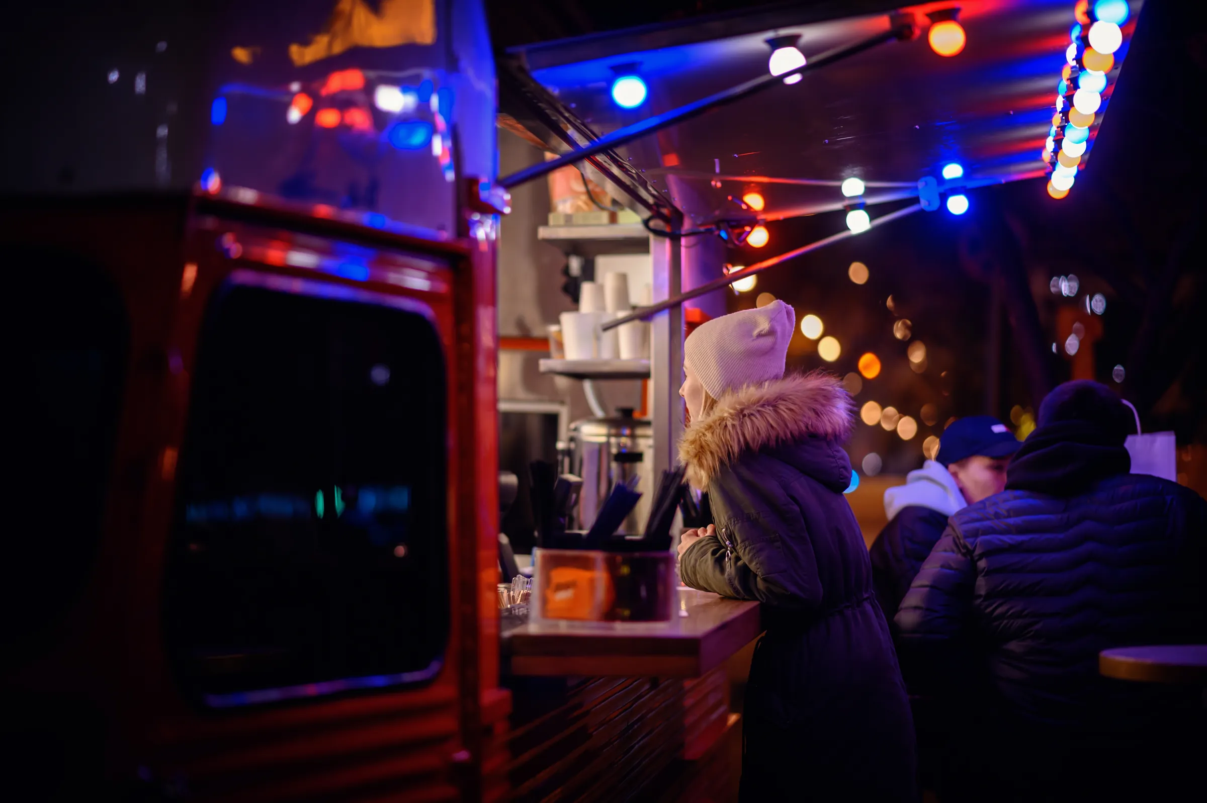 Foodtruck bei Nacht mit Gästen im Winter