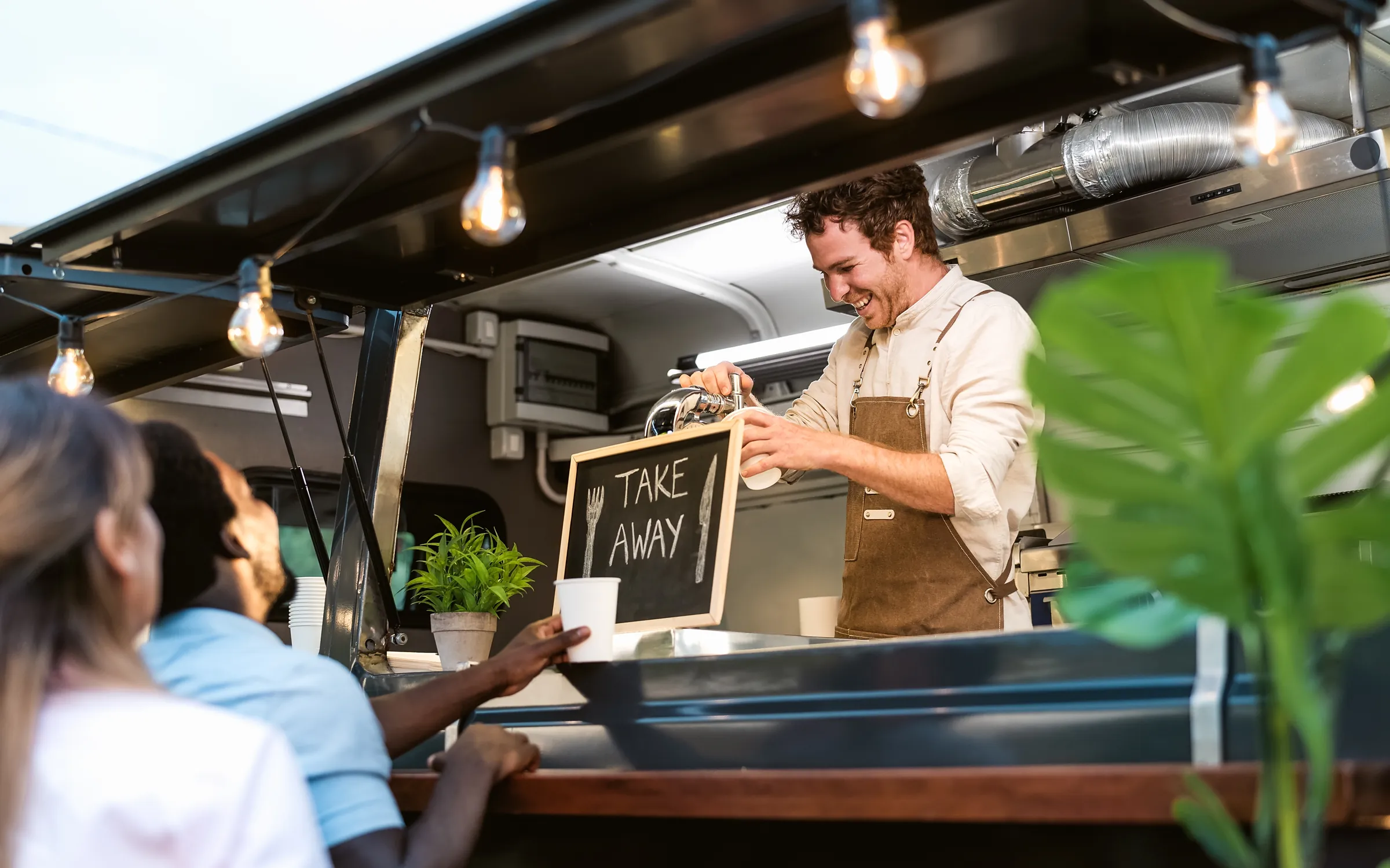 Koch gibt eine Take-away-Bestellung am Foodtruck aus
