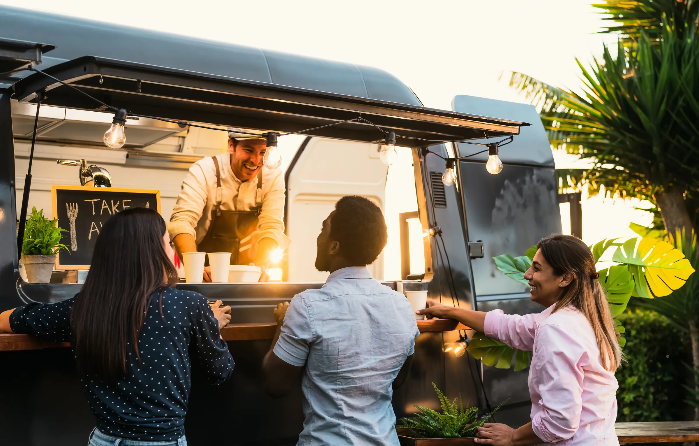 Gäste bestellen bei Sonnenuntergang am Foodtruck