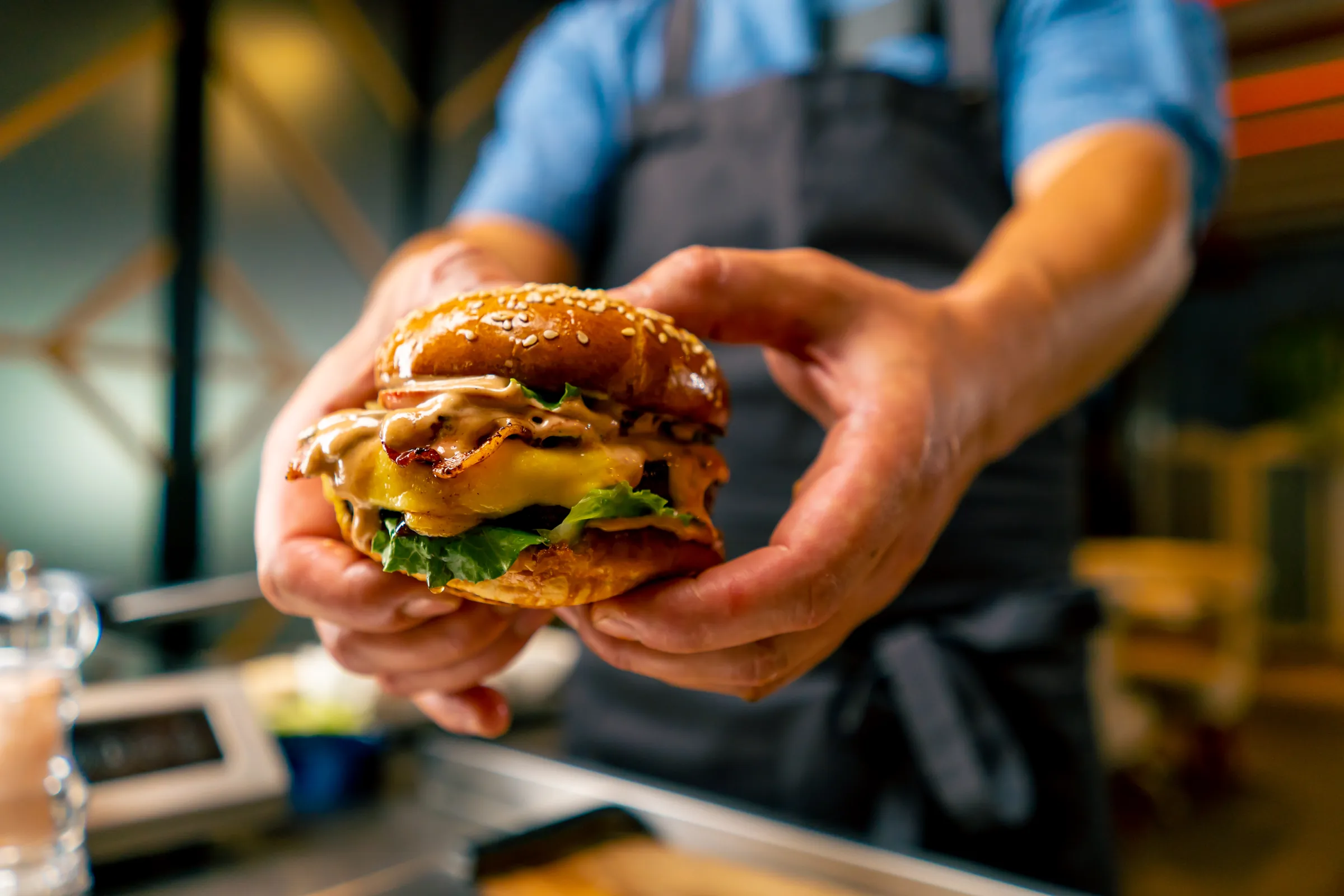 Koch präsentiert einen Cheeseburger im Foodtruck